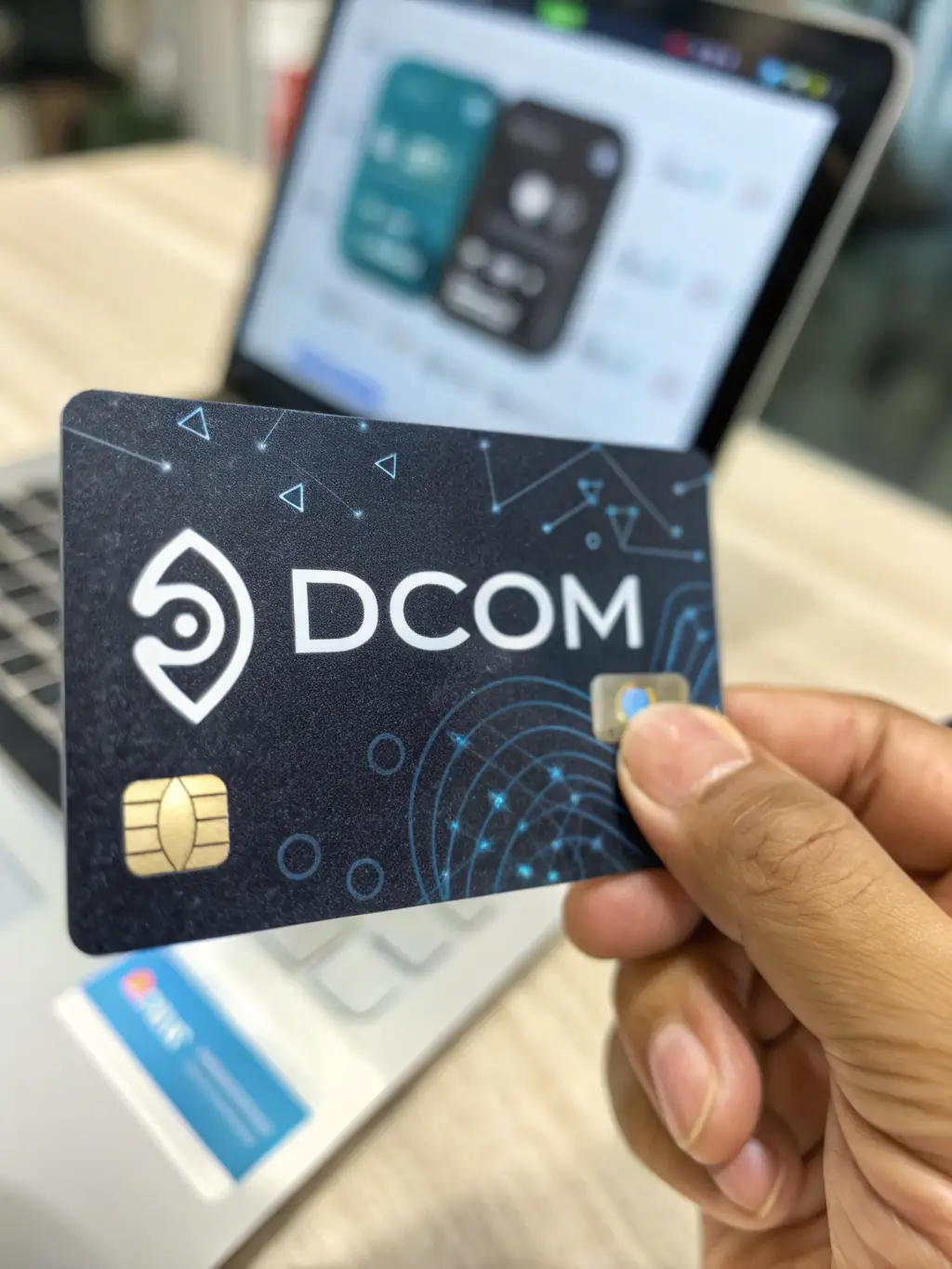 A close-up of a Dcom debit card displaying the Dcom logo and blockchain security features, emphasizing its reliability and security.